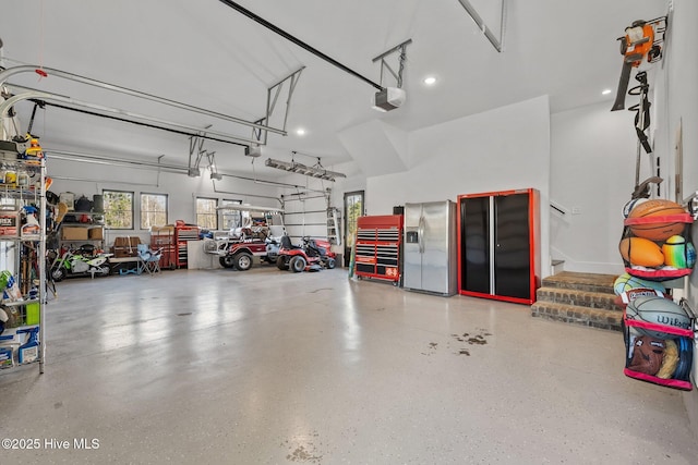 garage featuring stainless steel fridge with ice dispenser and a garage door opener