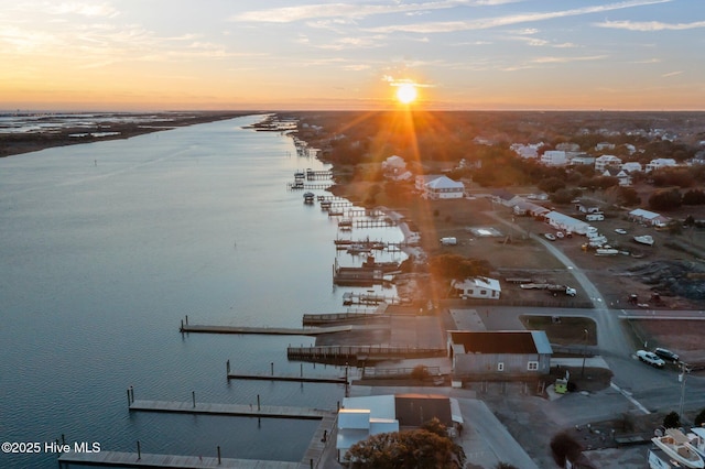 aerial view at dusk featuring a water view