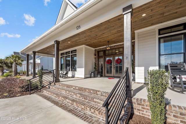 doorway to property featuring covered porch and french doors