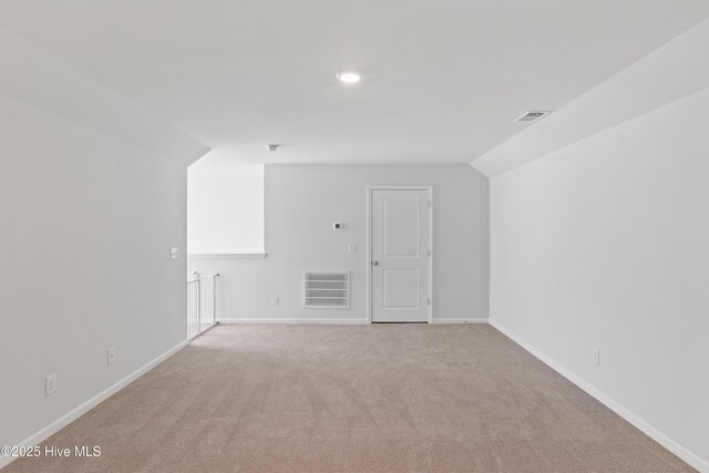 additional living space with vaulted ceiling and light colored carpet