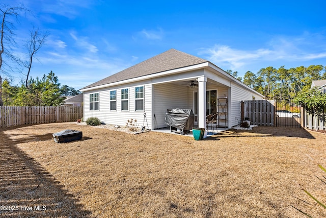 back of property with ceiling fan, a patio, and a lawn