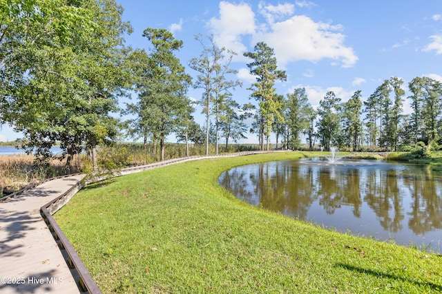 view of home's community featuring a water view and a yard