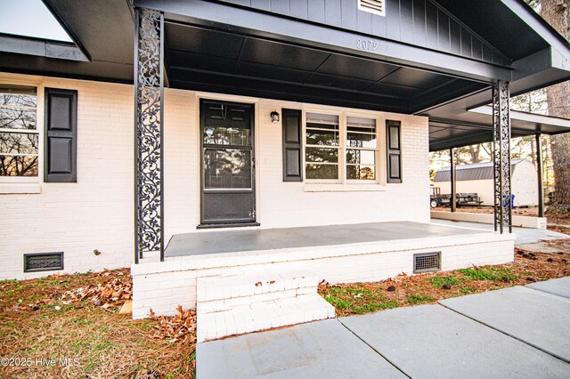 view of exterior entry featuring a porch