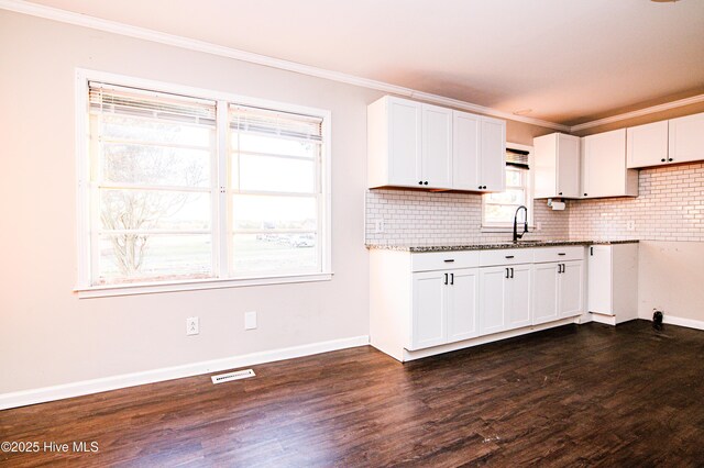 kitchen with dark hardwood / wood-style floors, white cabinetry, crown molding, and light stone counters