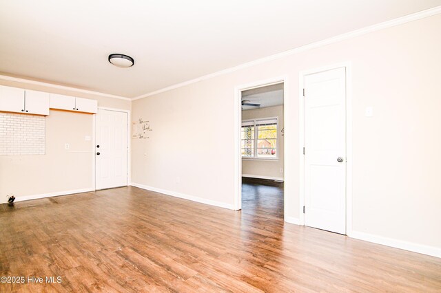 spare room with light hardwood / wood-style floors and crown molding