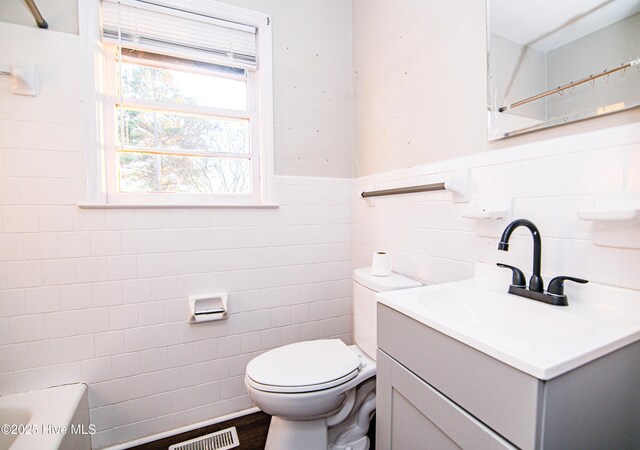 bathroom featuring hardwood / wood-style flooring, vanity, tile walls, and toilet