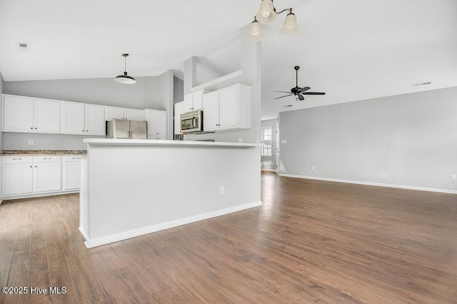 kitchen featuring appliances with stainless steel finishes, ceiling fan with notable chandelier, white cabinets, a kitchen island, and hanging light fixtures