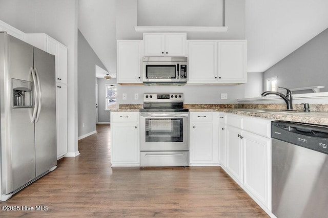 kitchen featuring dark wood-type flooring, white cabinets, sink, vaulted ceiling, and stainless steel appliances