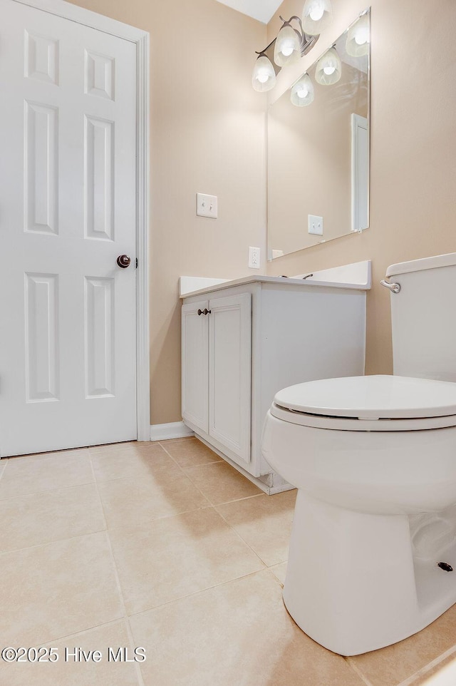 bathroom with tile patterned flooring, vanity, and toilet