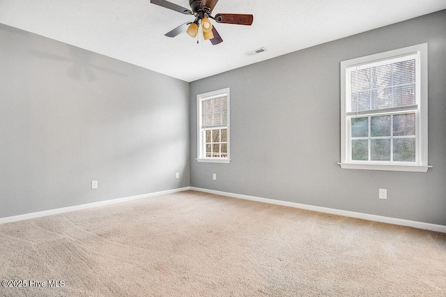 spare room with ceiling fan, a healthy amount of sunlight, and carpet floors