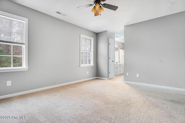 empty room featuring ceiling fan and light carpet