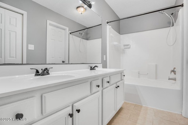 bathroom with shower / washtub combination, tile patterned flooring, vanity, and a textured ceiling