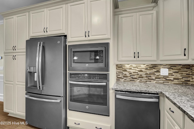 kitchen featuring dark wood-type flooring, stainless steel appliances, light stone countertops, and backsplash