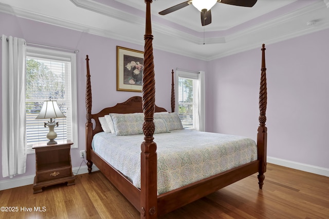 bedroom with multiple windows, crown molding, ceiling fan, and a tray ceiling