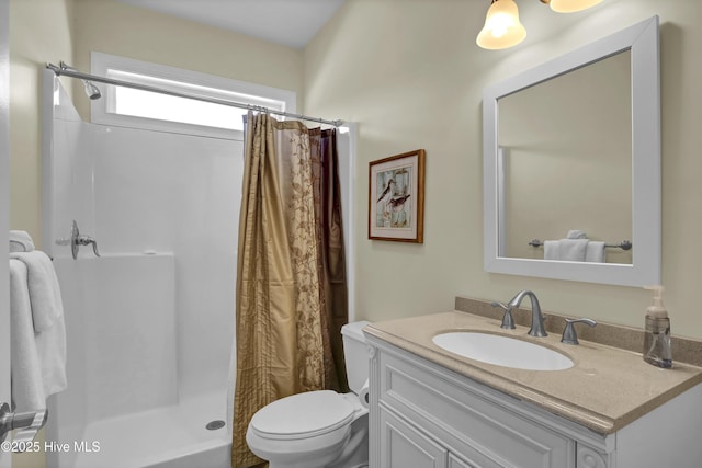 bathroom featuring vanity, toilet, and walk in shower