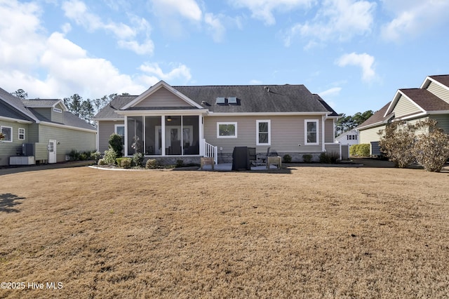 rear view of property with a patio, a sunroom, and a lawn