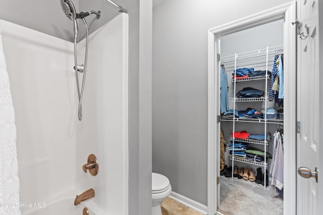 bathroom with tile patterned flooring, shower / bath combination, and toilet