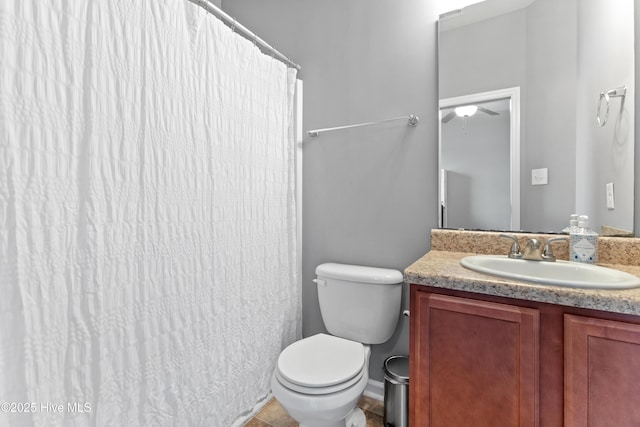 bathroom with toilet, vanity, and tile patterned floors