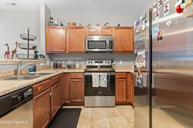 kitchen with sink, light tile patterned flooring, and stainless steel appliances