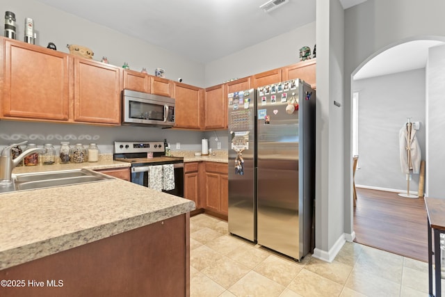 kitchen with light tile patterned flooring, sink, and appliances with stainless steel finishes