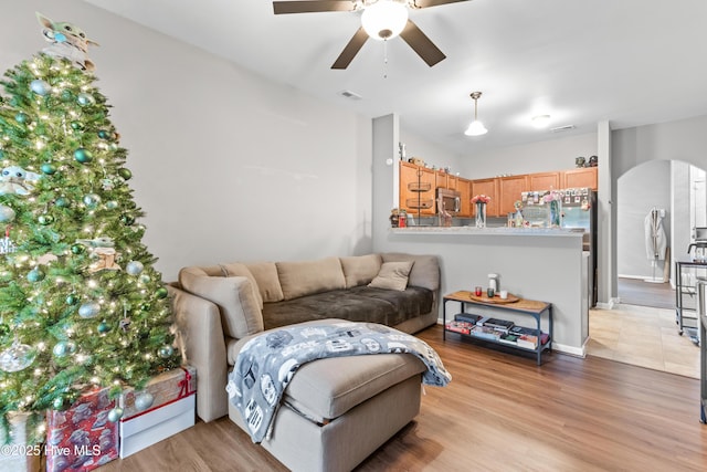 living room with ceiling fan and light wood-type flooring