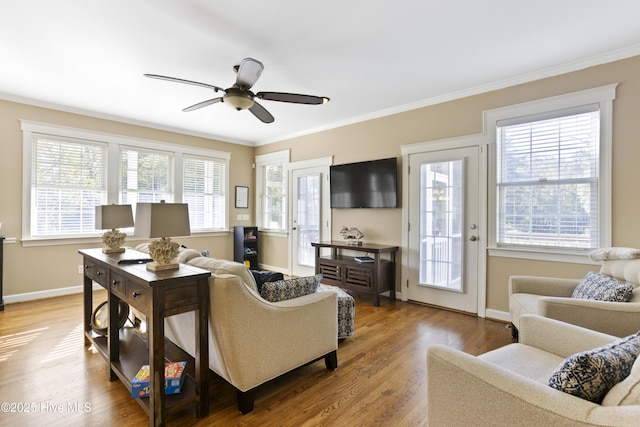 living room with a healthy amount of sunlight, baseboards, and wood finished floors