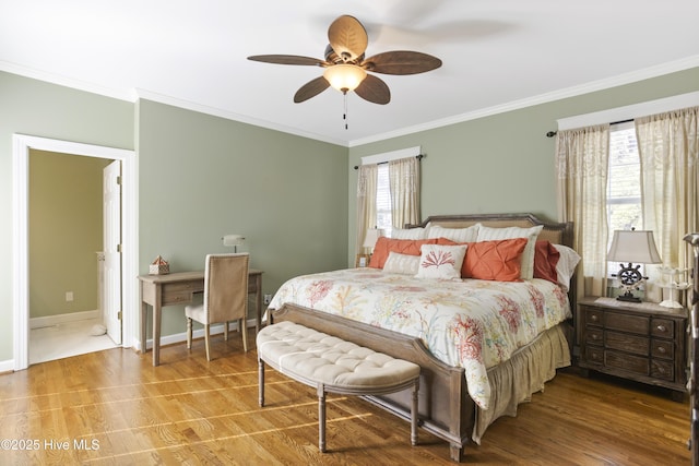 bedroom featuring baseboards, multiple windows, ornamental molding, and wood finished floors