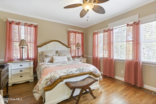 bedroom with crown molding, ceiling fan, wood finished floors, and baseboards