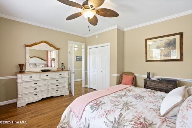 bedroom featuring ornamental molding, a closet, wood finished floors, and baseboards