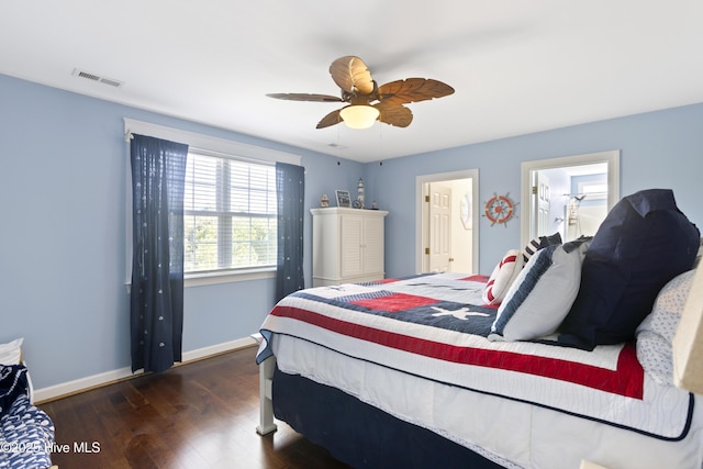 bedroom with a ceiling fan, visible vents, baseboards, and wood finished floors