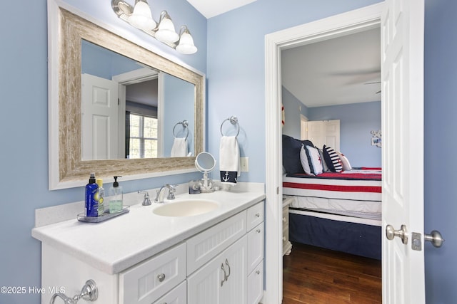 ensuite bathroom with wood finished floors, ensuite bath, and vanity