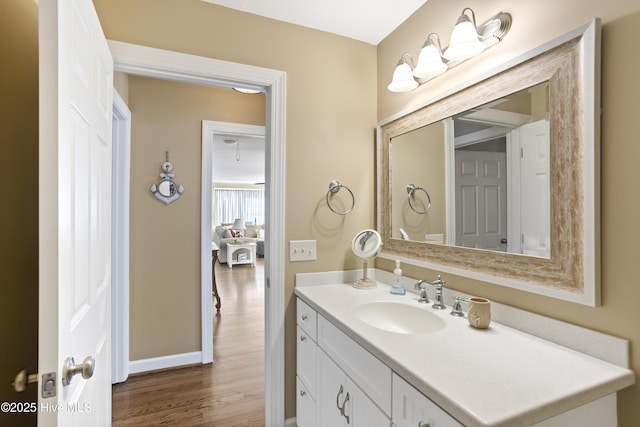 bathroom with wood finished floors, vanity, and baseboards