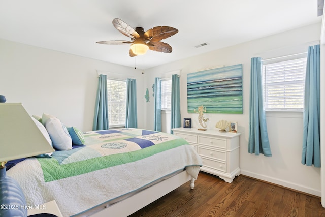 bedroom with visible vents, dark wood finished floors, baseboards, and ceiling fan