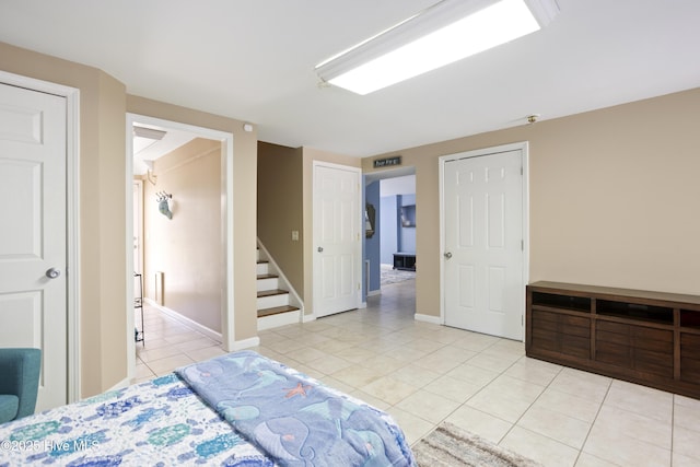 bedroom with light tile patterned flooring and baseboards