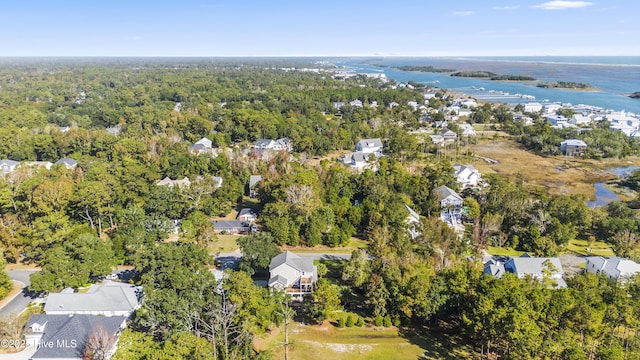 drone / aerial view with a residential view, a water view, and a view of trees