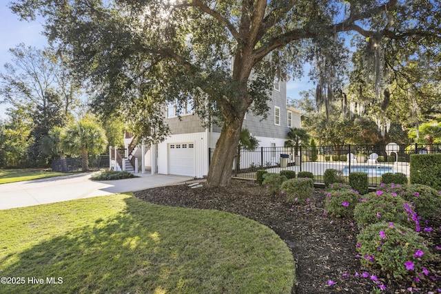 view of front of house with a garage, concrete driveway, a front yard, and fence