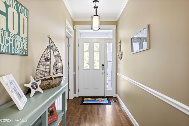 foyer entrance featuring ornamental molding, dark wood-type flooring, visible vents, and baseboards