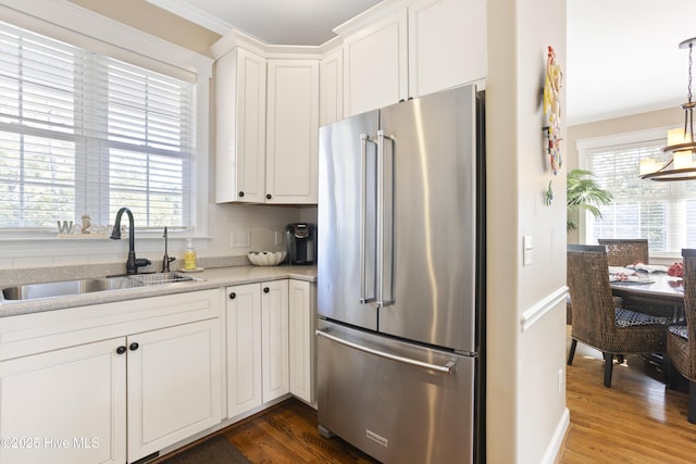 kitchen with high end fridge, dark wood-type flooring, a sink, and white cabinetry