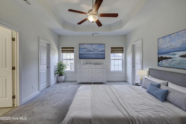 carpeted bedroom featuring a tray ceiling, ceiling fan, and ornamental molding