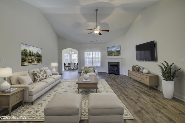 living room with ceiling fan, wood-type flooring, and vaulted ceiling