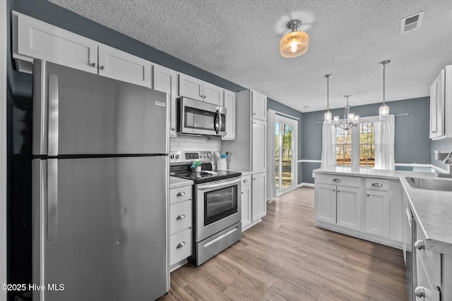 kitchen featuring decorative backsplash, stainless steel appliances, white cabinetry, and sink