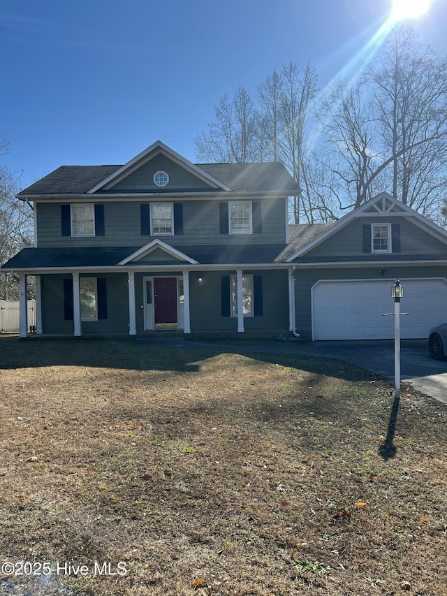 front of property with a front lawn, a porch, and a garage