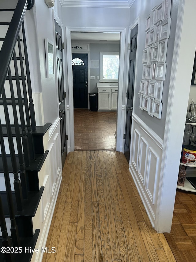 hallway with hardwood / wood-style flooring and ornamental molding