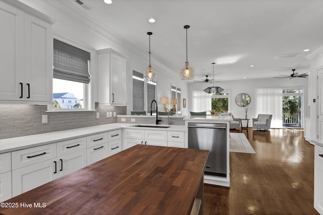 kitchen featuring white cabinets, tasteful backsplash, sink, pendant lighting, and dishwasher