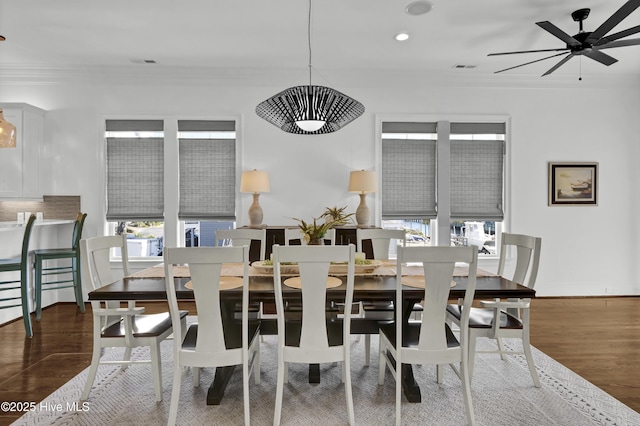 dining area featuring ceiling fan, ornamental molding, and dark wood-type flooring