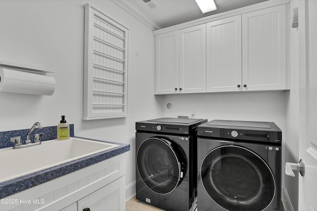 laundry room featuring crown molding, cabinets, sink, and washing machine and clothes dryer