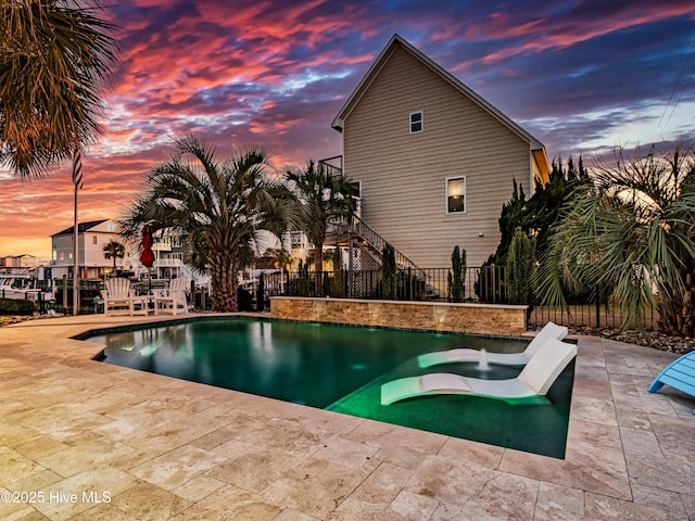 pool at dusk with a patio