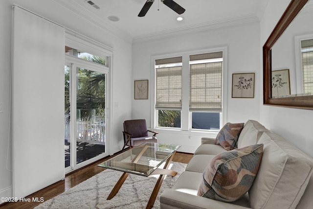 living room featuring a wealth of natural light, crown molding, ceiling fan, and dark hardwood / wood-style floors