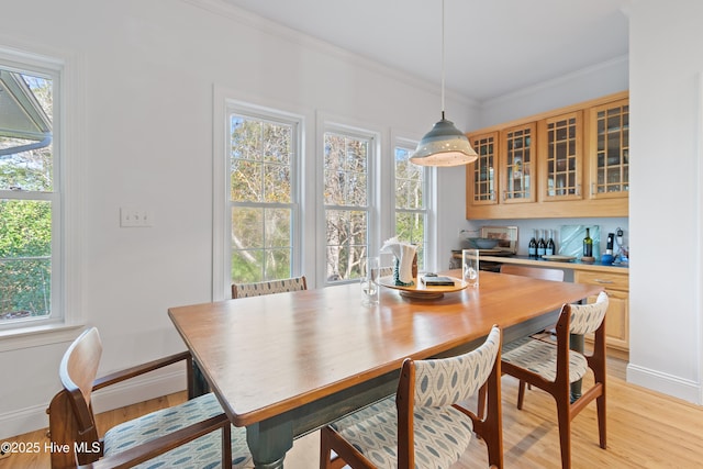 dining room featuring light wood-type flooring and ornamental molding