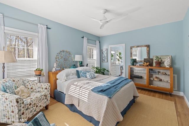 bedroom featuring ceiling fan, ensuite bathroom, and light hardwood / wood-style floors